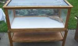 Custom made reptile habitat. Beautiful wooden structure--2 pieces includes the base with a shelf on bottom and the habitat which nestles neatly on the base. Easy to clean, plexiglass, reptile lamp and background, easy open screen top. Originally used to
