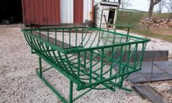 Well built steel round hay bale cradle feeder. 77 inches long, 72 inches wide, and 43 inches high. Has heavy duty steel runners for easy mobility. Has pins and tilts up for loading hay bale. Comes in hunter green. Weighs approximately 360 pounds. This is