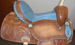 If You are looking for a beautifully decorated, rough out barrel racing saddle. Some of the special features are a rawhide horn, Leather seat, leather and rawhide wrapped stirrups, hand carved skirts, Blevins buckles, ultra soft and padded fleece and hand